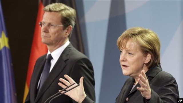 German Chancellor Angela Merkel, right, and Vice Chancellor Guido Westerwelle, left, address the media during a joint news conference Berlin, Germany, March 12, 2011
