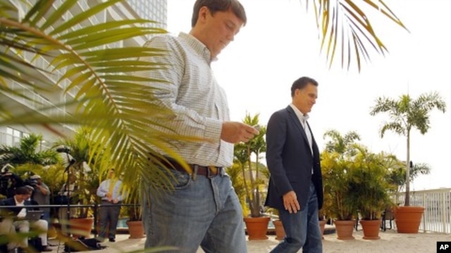 Republican presidential candidate and former Massachusetts Governor Mitt Romney and traveling press secretary Rick Gorka walk away after speaking to reporters in Tampa, January 23, 2012