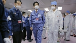 Japan's new prime minister, Shinzo Abe (C), tours the emergency operations center of the crippled Fukushima nuclear power plant December 29, 2012.