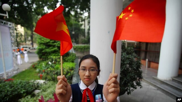 Học sinh Việt Nam cầm cờ  Trung Quốc đón ông Tập Cận Bình (ảnh tư liệu).