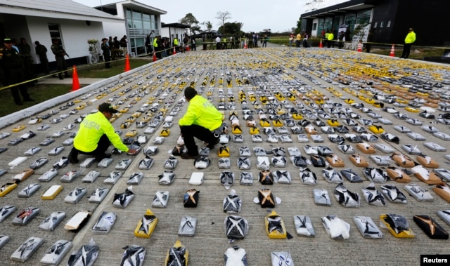 Colombian anti-narcotics policemen inspect packs of cocaine at the police base in Necocli, Feb. 24, 2015.