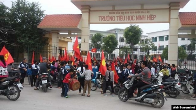 Hàng trăm học sinh tiểu học, trung học cơ sở tập trung trước cổng trường Ninh Hiệp phản đối việc xây trung tâm thương mại. (ảnh chụp từ trang thanhnien).