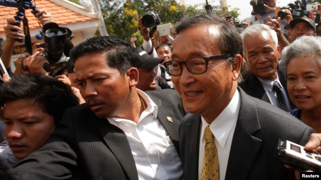 FILE - Sam Rainsy (R), leader of the opposition Cambodia National Rescue Party (CNRP), arrives at the Municipal Court in central Phnom Penh, Jan. 14, 2014. 