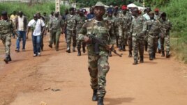 Guinea Bissau soldiers walk on October 21, 2012 in a street of Bissau after gunmen raided a Guinea-Bissau army barracks in the capital, sparking a firefight that left at least seven people dead in the latest unrest to blight the chronically unstable count
