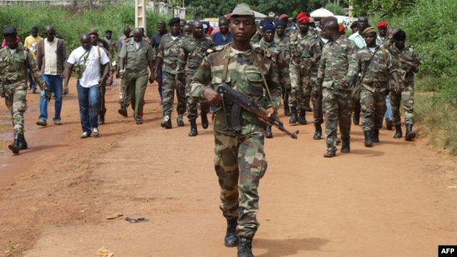 Guinea Bissau soldiers walk on October 21, 2012 in a street of Bissau after gunmen raided a Guinea-Bissau army barracks in the capital, sparking a firefight that left at least seven people dead in the latest unrest to blight the chronically unstable count