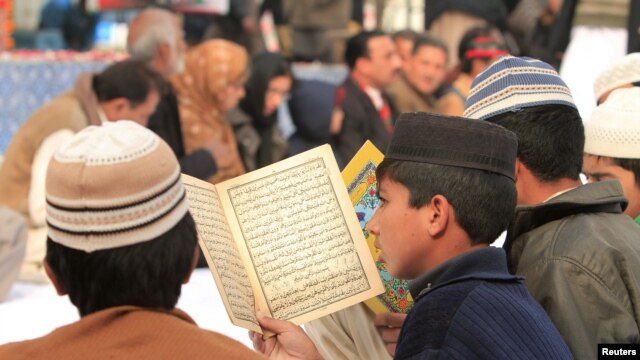 A supporter of Pakistan's former Prime Minister Benazir Bhutto reads the Koran to mark her death anniversary, at Liaquat Bagh in Rawalpindi near Islamabad December 27, 2012. Bhutto was killed in a gun and suicide bomb attack after an election rally in the