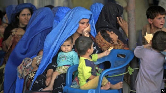 An Afghan woman sits amidst her children as they wait to be repatriated to Afghanistan from a United Nations Humanitarian Commission for Refugees (UNHCR) registration center in Peshawar, Pakistan, Jun 20, 2010 (file photo)