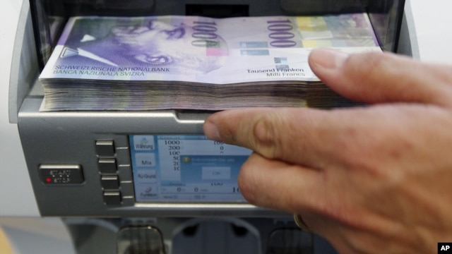 A bank clerk places1000 Swiss franc banknotes in a money counter in a Bank in Bern August 15, 2011. The Swiss franc rose against the euro and the dollar as renewed worries about the euro zone crisis pushed investors towards the safe-haven currency despite