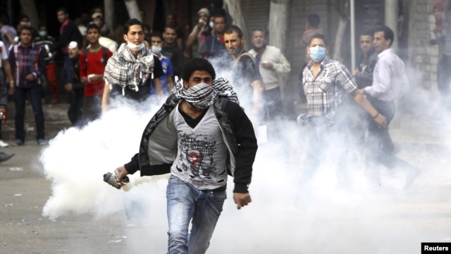 Người biểu tình chống Tổng thống Morsi ném hộp chứa khí hơi cay trong vụ đụng độ với cảnh sát chống bạo động tại Quảng trường Tahrir ở Cairo, ngày 27/11/2012.