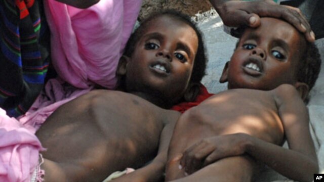 Two Somali children suffering from malnutrition lie at a camp for Internally Displaced People (IDP) near Mogadishu airport, July 2011.