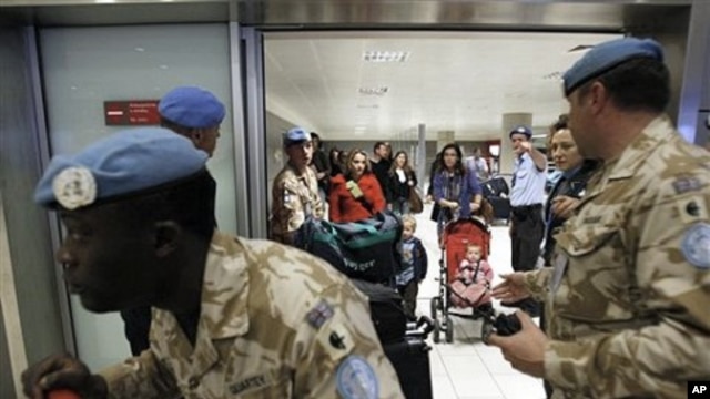 UN soldiers escort UN staff based in Egypt after they arrive in Cyprus' Larnaca airport, February 3, 2011.