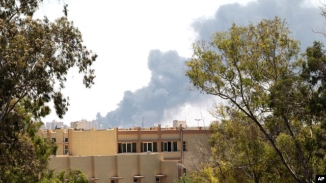 Smoke is seen after coalition air strikes in Tripoli, June 17, 2011
