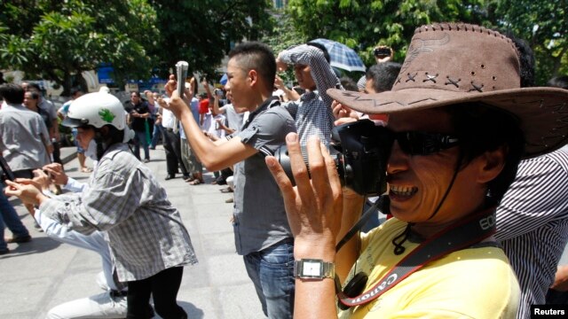 FILE - Blogger JB Nguyen Huu Vinh (front) takes photos while attending an anti-China protest in Hanoi.