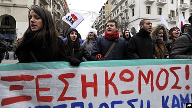 Protesters carry a banner which reads in Greek '' uprising '' during  a protest in the northern port city of Thessaloniki, Greece, February 11, 2012.