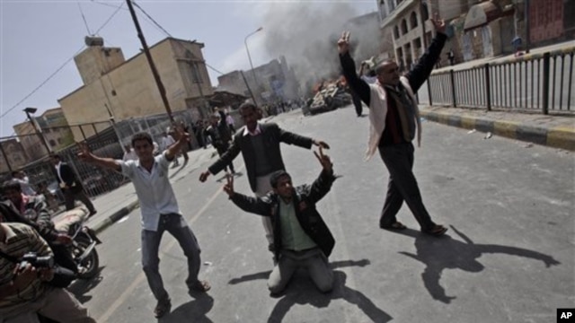 Yemeni anti-government demonstrators celebrate after setting on fire a vehicle belonging to supporters of President Ali Abdullah Saleh during clashes in Sana'a, Yemen, February 22, 2011