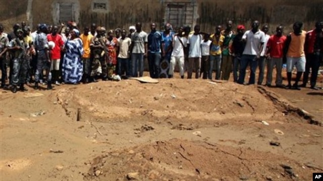 Local residents look on as republican forces soldiers visit the site of an alleged mass grave in a recently pacified area of the Yopougon district, in Abidjan, Ivory Coast, May 5, 2011