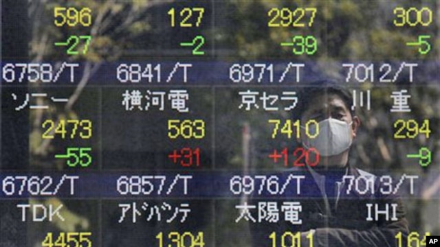 A reflection of a man who looks at the stock price board is seen in Tokyo,  March 17, 2011