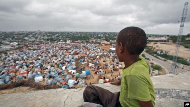 A boy sits looking over the Seyidka settlement for the famine stricken internally displaced people in Berkulan near Somalia's capital, Mogadishu, September 6, 2011.