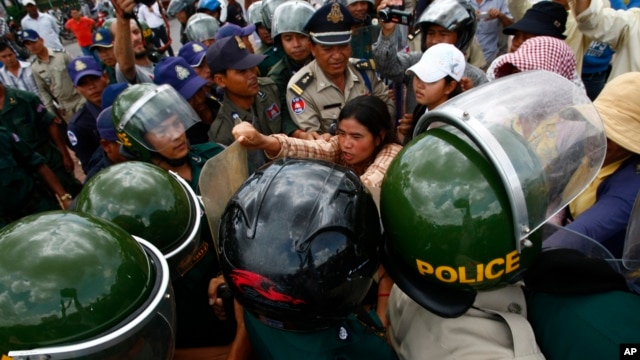 អ្នកស្រី​ទេព វន្នី សកម្មជន​ការពារសិទ្ធិ​លំនៅដ្ឋាន​នៅ​ចំកណ្តាលក្រុម​​ត្រូវប៉ូលិស​ដែលព្យាយាម​នាំ​អ្នកស្រី​ចេញ​ពីកន្លែង​តវ៉ា។ 