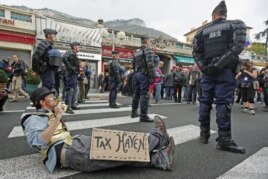 French gendarmes stand near an anti G20 demonstrator who takes part in protest against globalization and tax havens, at the French-Monaco border in Cap d'Ail, November 3, 2011.