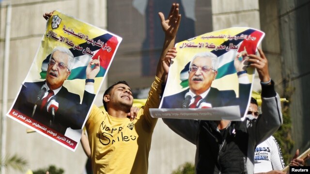 Người dân Palestine giơ cao những tấm áp phích có hình Tổng thống Mahmoud Abbas để ủng hộ những nỗ lực của ông trong việc bảo đảm một sự nâng cấp ngoại giao tại LHQ, 29/11/2012. 