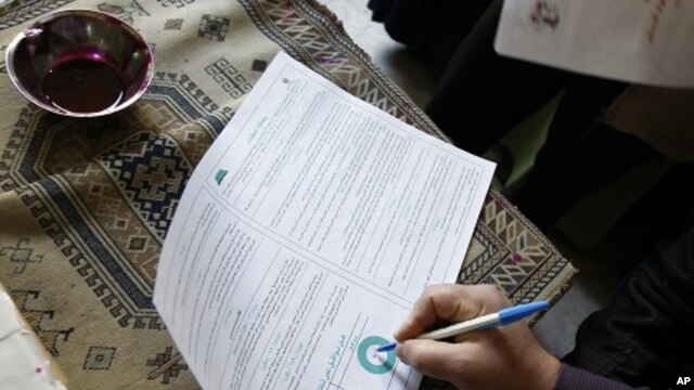 An Egyptian man fills in his ballot indicating "Yes" at a polling station during voting for a referendum on constitutional amendments at a polling station in Cairo (March 2011 file photo)