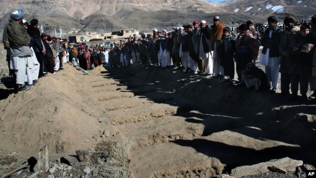Villagers stand in front of the graves of people killed during an explosion in Sayedabad, Wardak southwest of Kabul, Afghanistan, Jan. 13, 2013. 