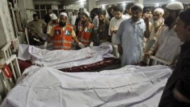 Police and hospital staff stand next to bodies of victims of a bomb attack, at the Lady Reading Hospital in Peshawar, August 31, 2012. 