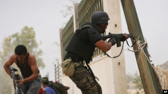 Libyan revolutionary fighters fire toward pro-Gadhafi forces in Sirte, Libya, Saturday, Oct. 8, 2011