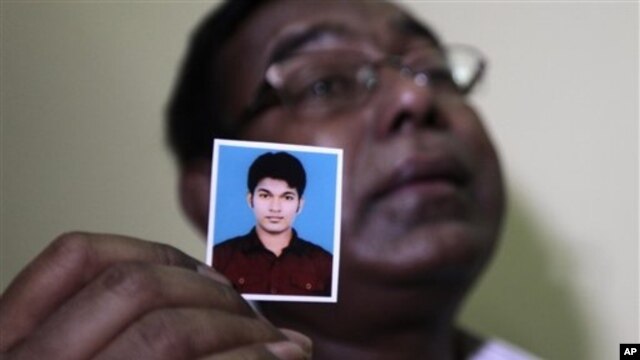 Quazi Ahsanullah displays photograph of his son Quazi Mohammad Rezwanul Ahsan Nafis, Dhaka, Bangladesh, Oct. 18, 2012.