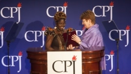 Mae Azango receiving CPJ award from AP Executive Editor Kathleen Carroll 