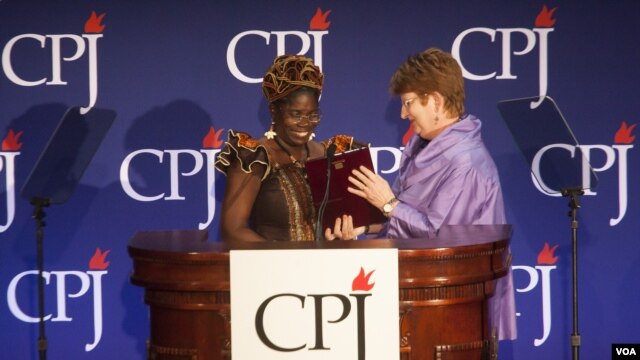 Mae Azango receiving CPJ award from AP Executive Editor Kathleen Carroll 