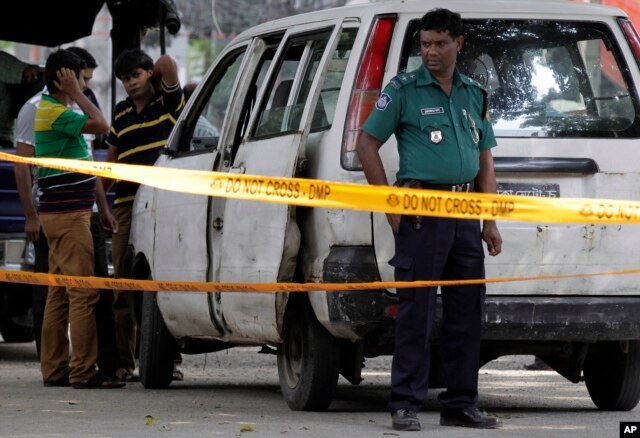 FILE - Members of Bangladeshi police and detective branch stand by the site a man was gunned down in Dhaka, Bangladesh, Sept. 29, 2015. Islamic militants claimed responsibility.