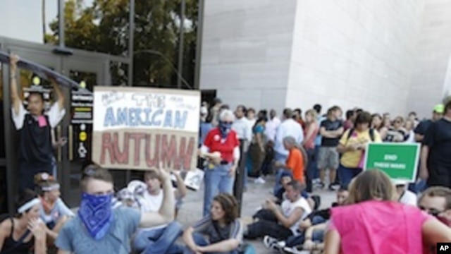 A group of demonstrators sit outside the entrance to the National Air and Space Museum in Washington after police pepper-sprayed a group of protestors trying to get into the museum Saturday, Oct. 8,  2011.