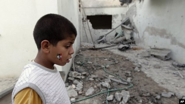 A Libyan child stands in a house damaged by a rocket supposedly fired by pro-Gadhafi forces and which injured four people in Misrata, Libya (File Photo - June 21, 2011)