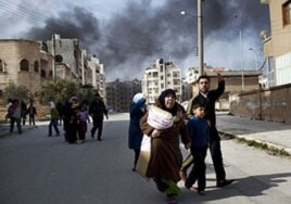 A family escapes from fierce fighting between Free Syrian Army fighters and government troops in Idlib, north Syria, March 10, 2012.