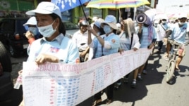 In this photo taken on Friday, May 4, 2012, Cambodian protesters from Boueng Kak lake march with a banner displaying the thumb prints of fellow land owners who have been evicted from their homes, as they demand compensation, in Phnom Penh, file photo. 