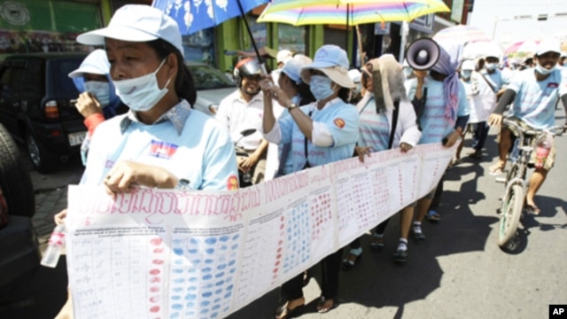 In this photo taken on Friday, May 4, 2012, Cambodian protesters from Boueng Kak lake march with a banner displaying the thumb prints of fellow land owners who have been evicted from their homes, as they demand compensation, in Phnom Penh, file photo. 