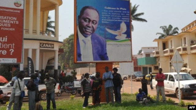 Residentes de Bangui ao pé de um poster do presidente da República Centro Africana, François Bozizé, 28 Dezembro 2012