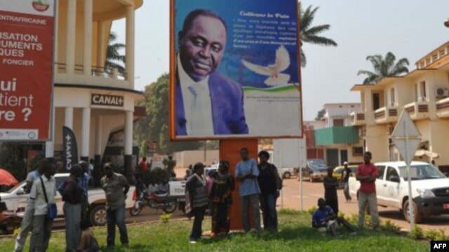 Beberapa orang berdiri di bawah poster Presiden Republik Afrika Tengah, Francois Bozize di Bangui (foto: dok). Kelompok pemberontak Seleka menuntut mundurnya Presiden Bozize.