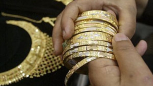 A buyer in Jammu, India chooses gold jewelry