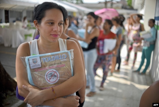 A pregnant woman holds a mosquito net in Cali, Colombia, Feb. 10, 2016. The Colombian Health Ministry began delivering mosquito nets for free to pregnant women to prevent the infection by Zika virus, vectored by the Aedes aegypti mosquito.