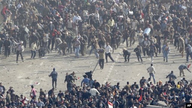 Pro-government demonstrators, below, and anti-government demonstrators, above, clash in Tahrir Square, the center of anti-government demonstrations, in Cairo, Egypt, February 2, 2011