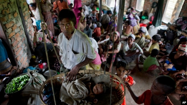 FILE - Internally displaced Rohingya people take shelter in a building ahead of the arrival of Cyclone Mahasen, in Sittwe, northwestern Rakhine State, Myanmar, May 15, 2013. 