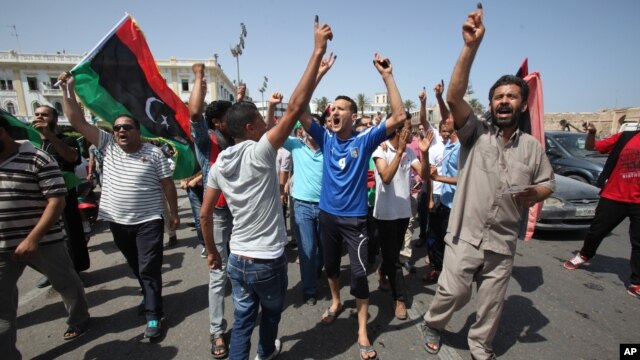 Libyans hold up their ink-marked fingers that shows they have voted as they celebrate in Martyrs' Square in Tripoli, July 7, 2012. 