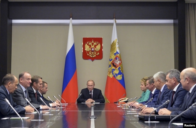 Russian President Vladimir Putin, center, meets with Security Council members at the Novo-Ogaryovo state residence outside Moscow, Sept. 30, 2015.