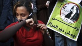 An Egyptian woman cuts her hair during a demonstration in Tahrir Square, Cairo, Egypt, Tuesday, Dec. 25, 2012.