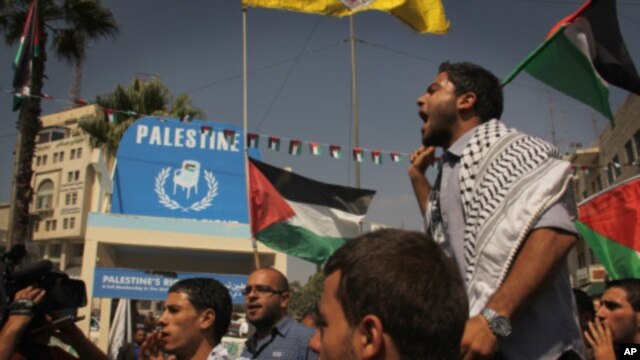 Palestinians march through Manara Square in central Ramallah passing a symbolic wooden chair erected to represent the UN seat they aspire, September 22, 2011