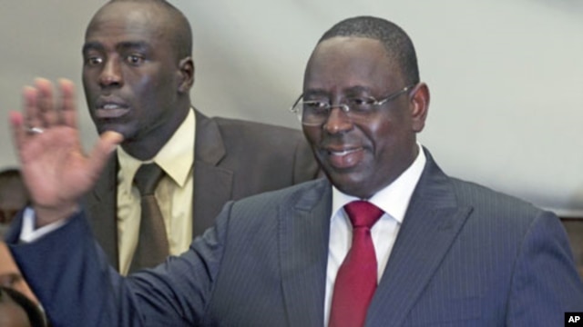 Senegalese opposition presidential candidate Macky Sall (R) celebrates at a news conference in Dakar, Senegal, March 25, 2012.