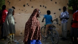 People walk through the heavily shelled police station in Gao, northern Mali, Feb. 11, 2013.